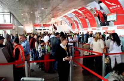 Un grupo de personas espera para hacer su registro en el terminal de la aerolínea Avianca, el pasado jueves 13 de septiembre de 2013, en Bogotá (Colombia).