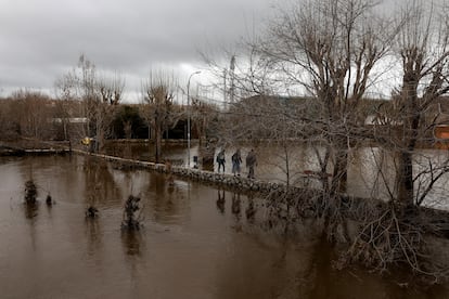 Un grupo de personas camina por un zona afectada por el agua en Ávila.