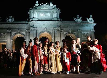 Personas disfrazadas de cortesanos frente a la Puerta de Alcalá, tras el tradicional desfile de Carnaval.