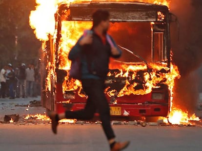 Autobús incendiado durante las protestas contra la enmienda a la ley de ciudadanía, este domingo en Nueva Delhi.