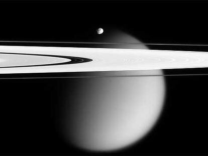 Image of two of Saturn's satellites: Titan (the big one) and Epimetheus (small, in the center). In the foreground, the rings of the planet. Photo taken by the Cassini probe on April 28, 2006.