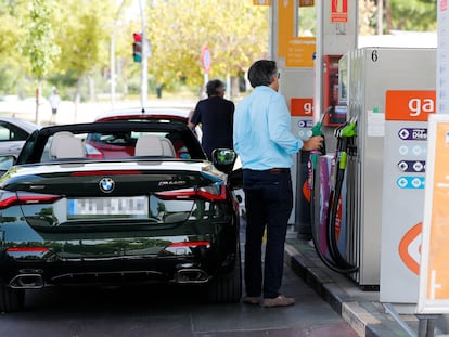 Unas personas repostan combustible en una gasolinera de Madrid.