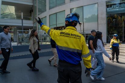 Brigadistas voluntarios dirigen a las personas en un centro comercial en Ciudad de México.