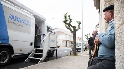 Un hombre sentado ante una oficina móvil de Abanca en Albarellos de Monterrei (Ourense), en 2019.