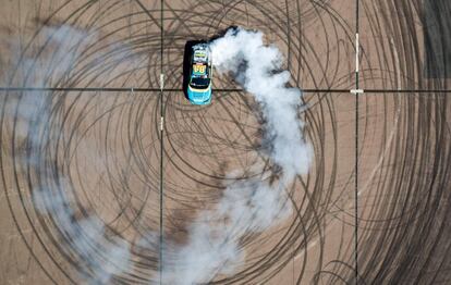 Fotografía tomada con un dron de un piloto profesional haciendo trompos con un coche de carreras en la ciudad de Ferropolis (Alemania), durante una manifestación.