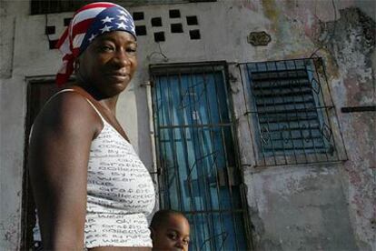 Una mujer camina con su hijo por La Habana Vieja, llevando en la cabeza un pañuelo con los colores de la bandera estadounidense.