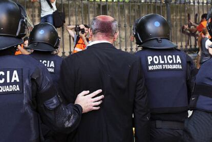 El diputado de ICV Joan Boada, con la cabeza manchada de pintura, entra en la Ciutadella escoltado por los Mossos d'Esquadra.