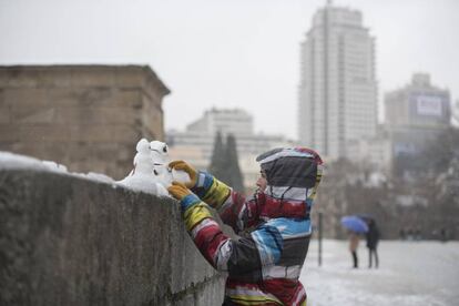 Una chica hace muñecos de nieve junto al Templo de Debod en Madrid, el 5 de febrero de 2018.