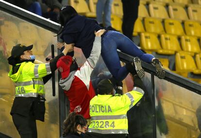 La policía ayuda a los aficionados de Santa Fe a abandonar la tribuna.