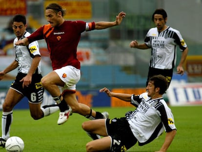 Totti se escabulle con la pelota entre tres defensas del Siena en el partido que perdió ayer el Roma.