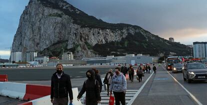 Una fila de personas se dirigen hacia el paso fronterizo entre Gibraltar y España.