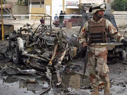 Un policía iraquí vigila la zona de Bagdad donde se produjo ayer un atentado con coche bomba.