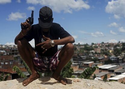 Un pandillero apodado 'Petardo' de 22 años, posa con un arma de fuego sobre una colina con vistas a uno de los barrios más pobres de Salvador de Bahía (Brasil).