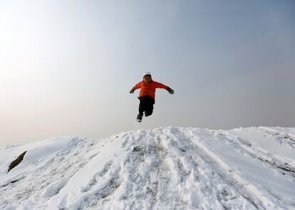 Un niño afgano juega en la nieve a las afueras de Kabul (Afganistán).