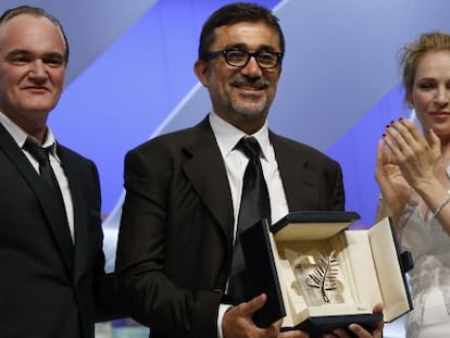 El director turco Nuri Bilge Ceylan  recoge la Palma de oro rodeado de Quentin tarantino y Una Thurman. 
