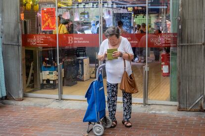 Una mujer revisa su monedero a la salida del mercado de Hostafrancs, en Barcelona.