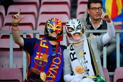 Una pareja de aficionados de ambos equipos en la grada del Camp Nou.