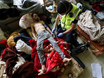 Youssef Bouzidi, un solicitante de asilo marroquí que está en huelga de hambre durante más de un mes, es examinado por un trabajador de la salud en una habitación en el campus de la universidad de Bélgica ULB, el 29 de junio de 2021.