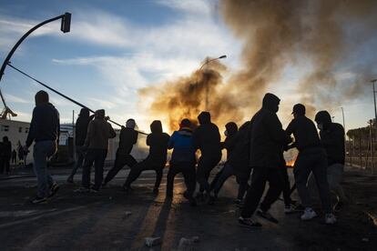 Un grupo de trabajadores del metal tiran de una manguera para tumbar el semáforo de la carretera Industrial de Cádiz.