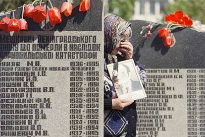Una viuda llora a su marido ante el monumento erigido en Kiev en memoria de los fallecidos por el accidente nuclear de Chernóbil.