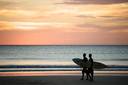 Dos surferos caminan por la Playa Avellana en Costa Rica.