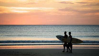 Dos surferos caminan por la Playa Avellana en Costa Rica.