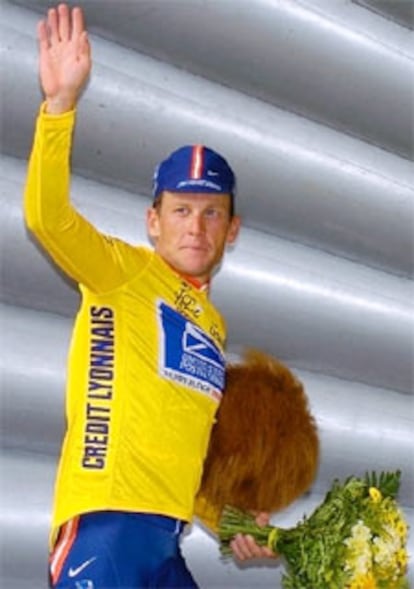 Armstrong saluda tras abandonar el podio como vencedor de la etapa.