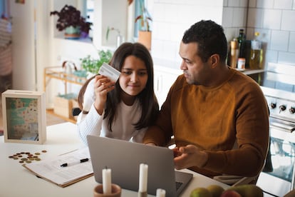 Un padre enseña a su hija a comprar por Internet desde su laptop