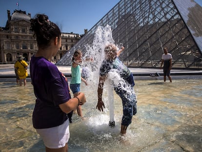 Unas personas se refrescaban el martes en una de las fuentes del Museo del Louvre, en París.