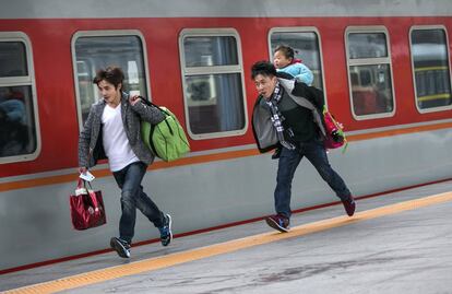 Dos viajeros corren para tomar su tren en Hangzhou el pasado domingo.