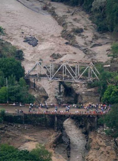 Habitantes de la localidad salvadoreña de Zacatecoluca observan los daños causados por la crecida de un río tras las lluvias torrenciales.