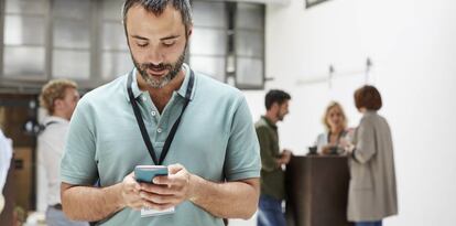 Un hombre envía un mensaje con su smartphone.