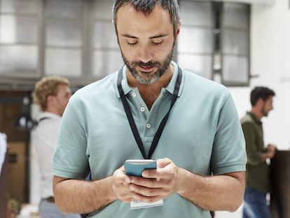 Un hombre envía un mensaje con su smartphone.