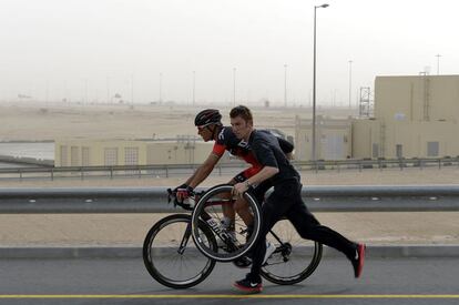 Un mecánico empuja al ciclista belga Philippe Gilbert después de haberle cambiado un neumático pinchado durante la segunda etapa del Tour de Qatar 2015.