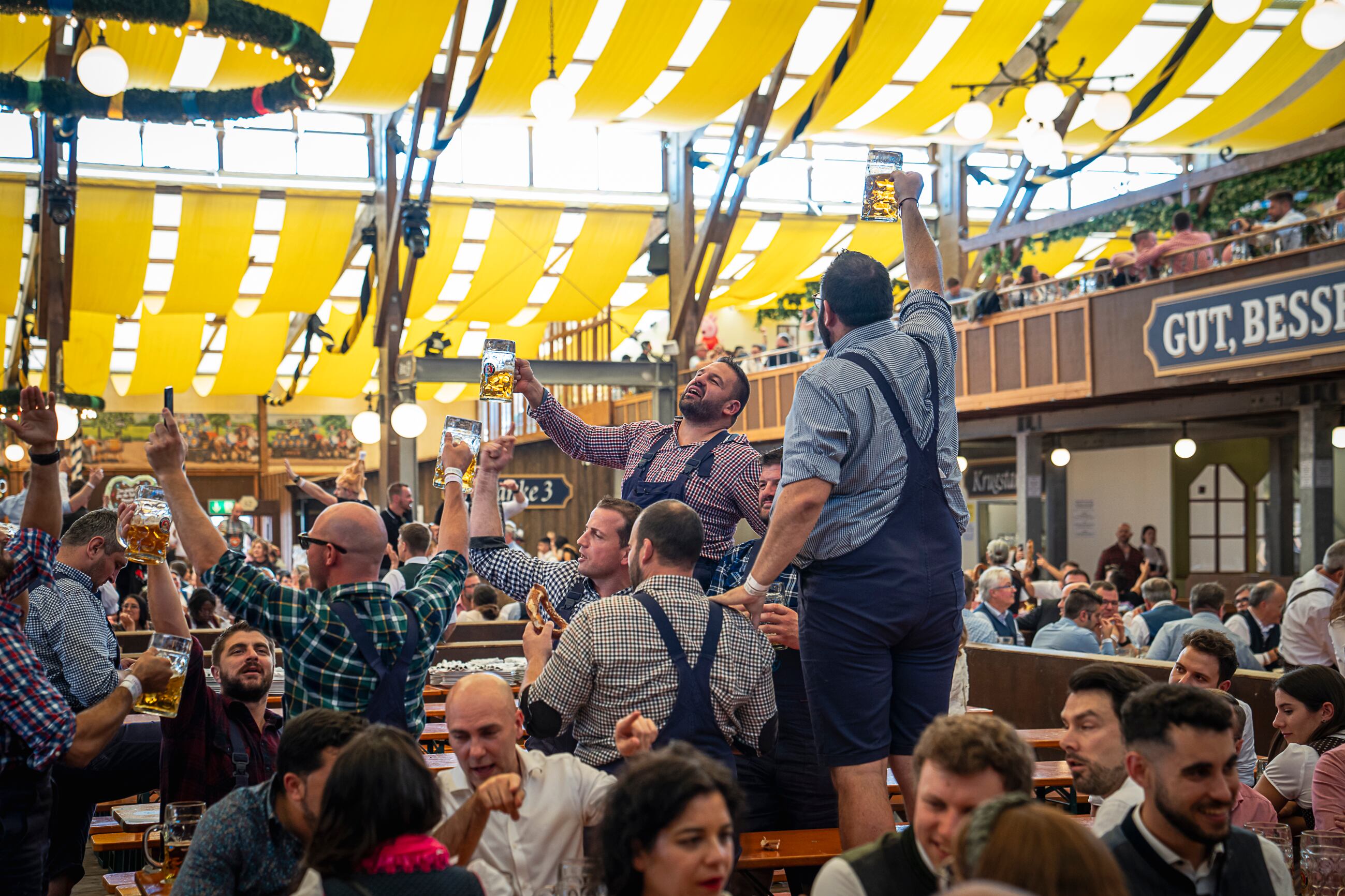 Asistentes al Oktoberfest cantan subidos a las mesas de la carpa de Paulaner.