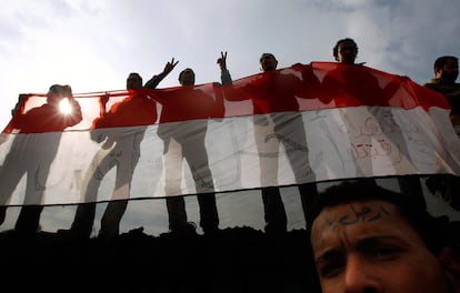 Manifestantes antigubernamentales agitan una bandera egipcia en la que se puede leer: "Mubarak asesino".