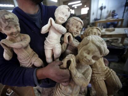 Un carpintero muestra figuras cristianas en un taller en Belén, Palestina.