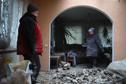 Vecinos de Stanytsia Luhansk, cerca de la línea del frente, en la parte controlada por el Gobierno ucranio, observan los daños causados por un ataque en su casa, el pasado viernes. 