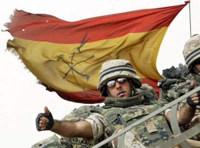 Un legionario español saluda desde un blindado antes de cruzar la frontera con Kuwait durante la retirada de las tropas de Irak en mayo de 2004.
