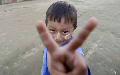 Un niño refugiado birmano hace el signo de la victoria, en el campo de refugiados de Janmai Baptist, en la ciudad de Myitkyina (Birmania), el 28 de octubre de 2013.