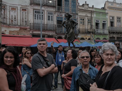 An African-heritage tour guide explains the history of Mercedes Baptista in front of a statue of the dancer