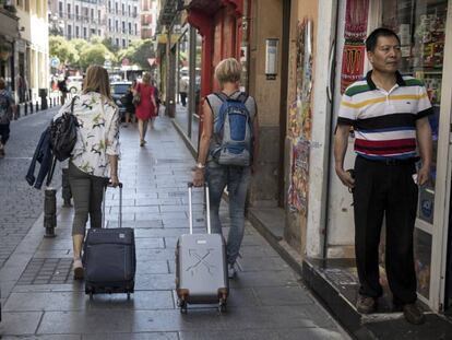 Dos turistas con sus maletas por el centro de Madrid.