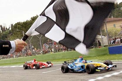 Fernando Alonso (cruza vencedor la línea de meta seguido por el Ferrari de Michael Schumacher al término del Gran Premio de San Marino de 2005.