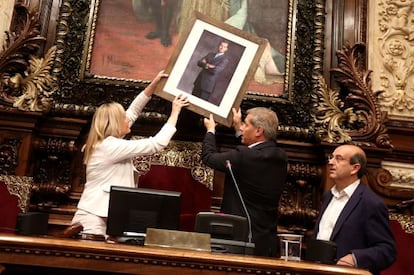 The PP leader in Barcelona, Alberto Fernández Díaz, places the portrait of Felipe VI inside city council.