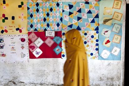 Una mujer pasa frente a una pared de una escuela en la que se muestran los trabajos de los pequeños. Va completamente tapada porque sabe que va a ser fotografiada. La religión mayoritaria y con gran influencia en el valle de Hushé es la rama sufí del Islam. Son pueblos pacíficos contrarios a sus vecinos de Afganistán. Uno de los motores económicos de esta zona es el comercio del albaricoque seco –los orejones–. Muchos en el valle se dedican a su cultivo, ya que el clima seco le favorece. Es una zona en la que no llega el monzón, el Himalaya actúa como muralla e impide el paso de las lluvias.