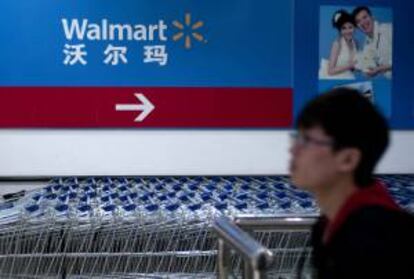 Un hombre camina junto a varios carritos de la compra en un walmart en Qingdao (China). EFE/Archivo