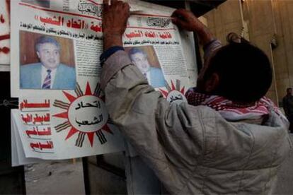 Un hombre cuelga en Bagdad propaganda electoral del Partido Comunista de Irak.