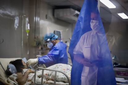 Dos trabajadores del Hospital de Clínicas de San Lorenzo (Paraguay) trabajan con una enferma de covid-19.