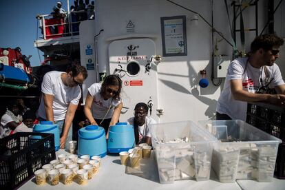 Miembros de MSF preparan la primera comida del día para repartirla entre los migrantes rescatados que esperan poder desembarcar en algún puerto europeo, el 11 de junio de 2018.