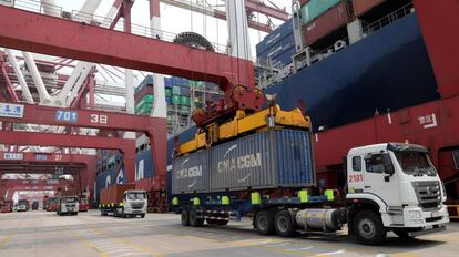 Un camión mientras descarga un contenedor en el puerto de Qingdao (China).
